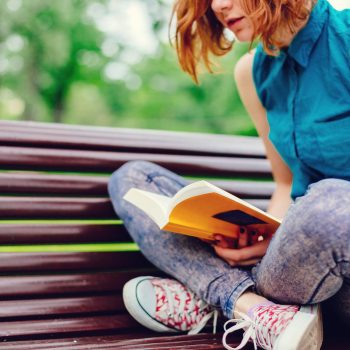 Girl reading a book outside