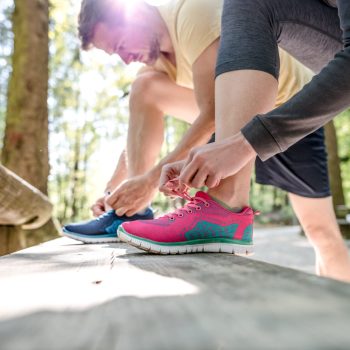 Couple tying their exercise shoes.